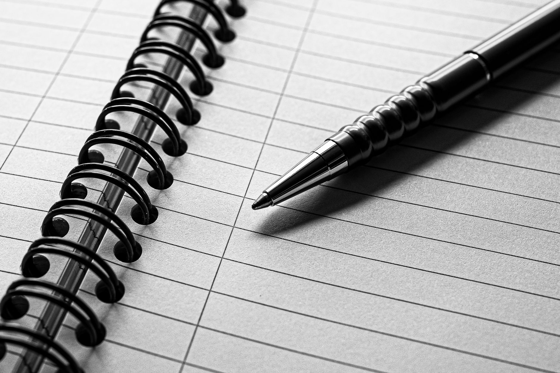 black and white spiral notebook with pen